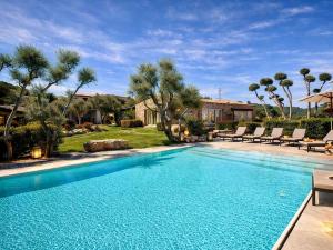 a swimming pool in a yard with chairs and trees at Pedra Smeralda in Golfo Aranci