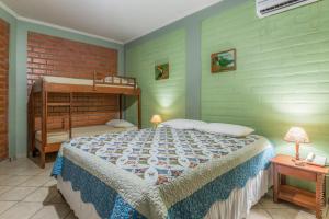 a bedroom with a large bed and a bunk bed at Pousada Rancho Jarinu in Bonito