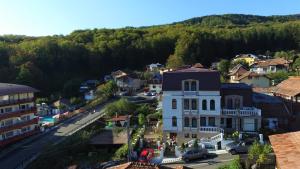 widok z powietrza na małe miasteczko z białym budynkiem w obiekcie Pensiunea Eden w mieście Băile Olăneşti