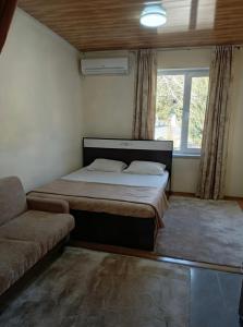 ein Schlafzimmer mit einem Bett, einer Couch und einem Fenster in der Unterkunft Alp Hotel in Qax + 87 Fotos