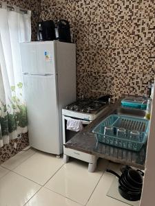 a kitchen with a stove and a white refrigerator at Refúgio Rio Soberbo in Guapimirim +14 photos