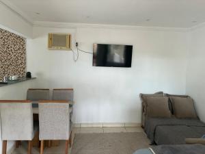 a living room with a couch and a tv on the wall at Refúgio Rio Soberbo in Guapimirim