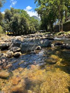 a river with rocks and trees on the side at Refúgio Rio Soberbo in Guapimirim