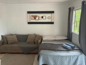 a living room with a couch and a bed at Refúgio Rio Soberbo in Guapimirim