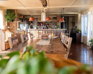 a restaurant with a large wooden table and chairs at El Abrazo de las Sierras in Minas