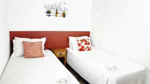 two beds sitting next to each other in a room at Pousada Dinhá Chica perto de Tiradentes e Bichinho in São João del Rei