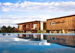 a house with a pool of water in front of it at El Abrazo de las Sierras in Minas