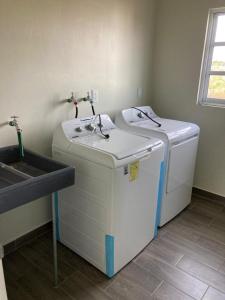 a laundry room with a sink and a washing machine at Brisa Marina in Playa Agua Blanca +70 photos