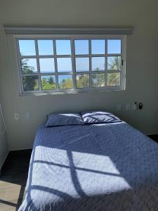 a bedroom with a bed with a blue blanket and a window at Brisa Marina in Playa Agua Blanca
