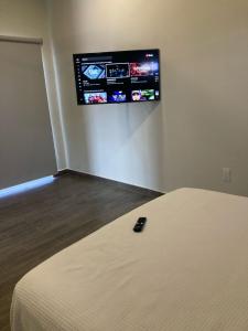 a room with a bed and a tv on the wall at Brisa Marina in Playa Agua Blanca