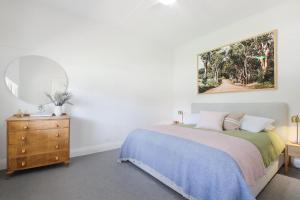 a bedroom with a bed and a mirror and a dresser at The Gums, Beechworth in Beechworth