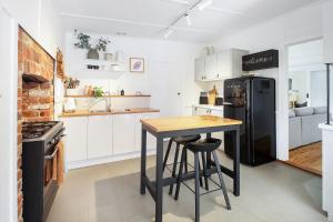 a kitchen with a table and a black refrigerator at The Gums, Beechworth in Beechworth
