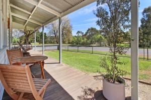 a porch with a table and chairs and a tree at The Gums, Beechworth in Beechworth