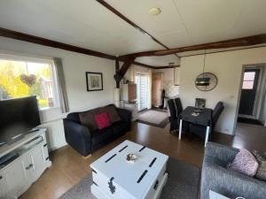 a living room with a couch and a table at B&B Schoonloo - boerderij appartementen in Schoonloo