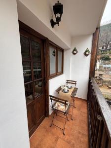 a balcony with a table and chairs and a wooden door at El Castaño in Guisando +26 photos