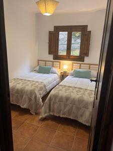 a bedroom with two beds and a window at El Castaño in Guisando