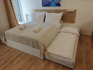 a large bed with two slippers on top of it at Apartmán SOVA - Klínovec in Loučná pod Klínovcem