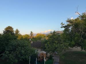 a house in the middle of trees with mountains in the background at Casa Felice 1910 in Introdacqua