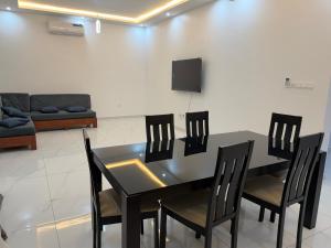 a dining room with a table and chairs and a couch at Résidence L H in Yaoundé