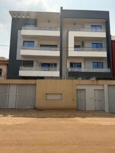 an apartment building with garages in front of it at Résidence L H in Yaoundé