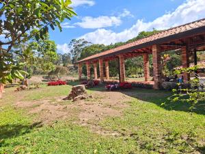 a garden with a pavilion with flowers and a rock at Hotel Cristo Rey Campestre in Los Santos