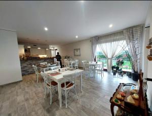a dining room with tables and chairs and a kitchen at B&B CasalFarano in Cupra Marittima