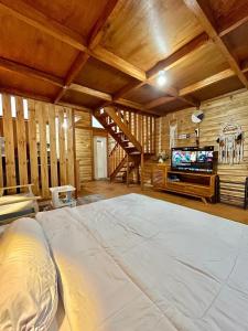 a large room with a bed and a tv at Miarzafa Cabin House DIENG in Kejajar