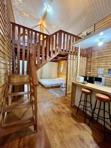 a wooden staircase in a room with a desk and stool at Miarzafa Cabin House DIENG in Kejajar