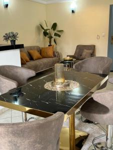 a living room with a glass table and chairs at Nsenou Tower in Yaoundé