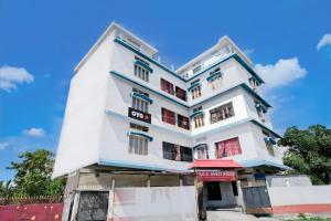 a tall white building with a sign on it at SPOT ON S.D.S GUEST HOUSE in Guwahati