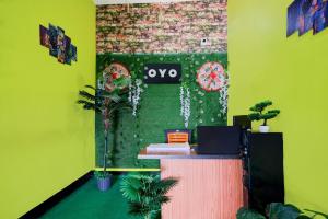 an office with a desk and a green wall at SPOT ON S.D.S GUEST HOUSE in Guwahati