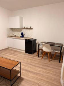 a kitchen with a table and chairs in a room at 4-person apartment in Joeuf +1 photo