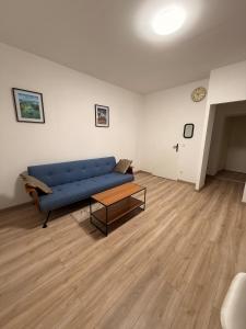 a living room with a blue couch and a coffee table at 4-person apartment in Joeuf