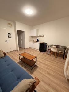 a living room with a blue couch and a table at 4-person apartment in Joeuf