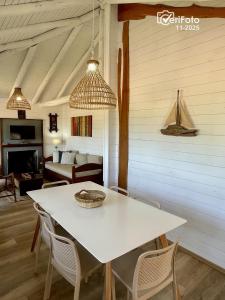 a dining room with a white table and chairs at OHANA in Punta Del Diablo
