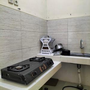 a stove top in a kitchen with a sink at Villa Graha Dewata in Malang