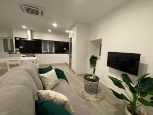 a living room with a gray couch and a tv at Casa do Pelourinho in Arcos de Valdevez