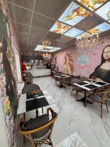 a restaurant with tables and chairs and paintings on the walls at HOSTAL PARIS TALCA in Talca