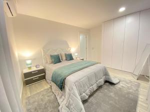 a bedroom with a large bed and a night stand at Casa do Pelourinho in Arcos de Valdevez