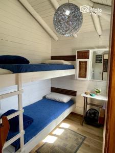 a room with two bunk beds and a chandelier at OHANA in Punta Del Diablo
