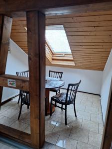 a dining room with a table and chairs and a skylight at Ferienwohnung Silchmüller in Zella-Mehlis +12 photos