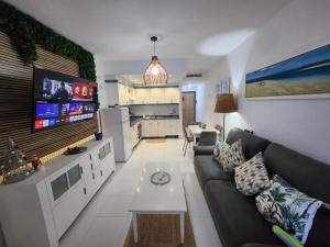 a living room with a couch and a tv at Ocean Luxury Apartment in Mogán