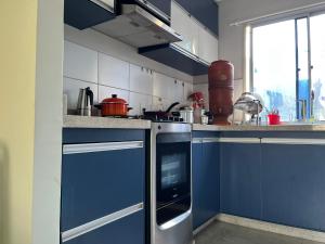 a blue and white kitchen with blue cabinets at Quarto Premium c Ar e Wi-Fi - Próximo à Ponte JK in Brasília