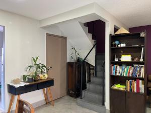 a living room with a staircase and a book shelf at Quarto Premium c Ar e Wi-Fi - Próximo à Ponte JK in Brasília