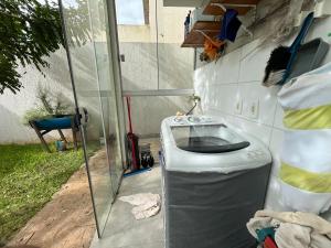 a bathroom with a toilet next to a glass door at Quarto Premium c Ar e Wi-Fi - Próximo à Ponte JK in Brasília +17 photos