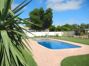 a swimming pool in a yard with a fence at Longreach Tourist Park in Longreach