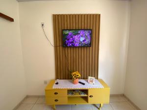 a yellow table with a flower on top of a wall at Casa Becker in Laranjeiras do Sul