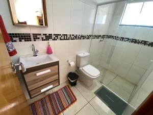 a bathroom with a shower and a toilet and a sink at Casa Becker in Laranjeiras do Sul +5 photos