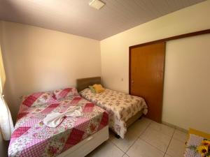 a small bedroom with two beds and a door at Casa Becker in Laranjeiras do Sul