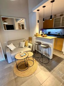 a living room with a couch and two tables and a kitchen at Espacio Nidra - Tu descanso a pasos del Aeropuerto in Ezeiza